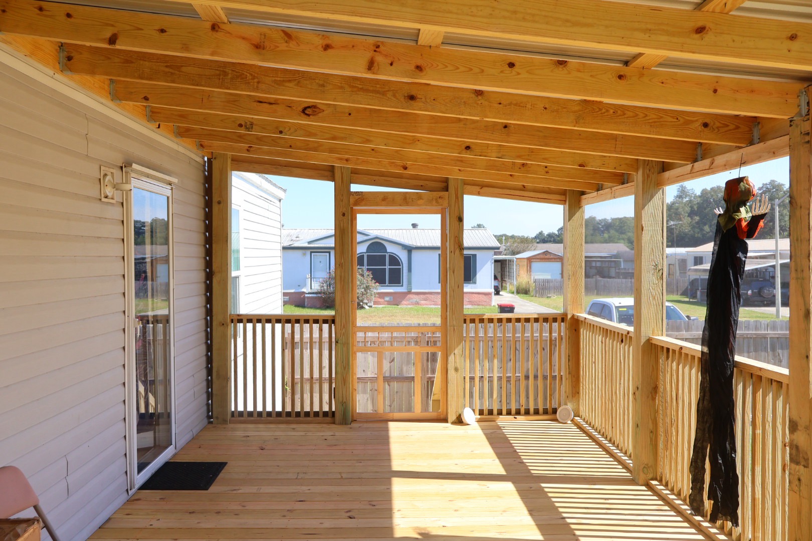 Finished screened porch with new decking, railing, and covered roof